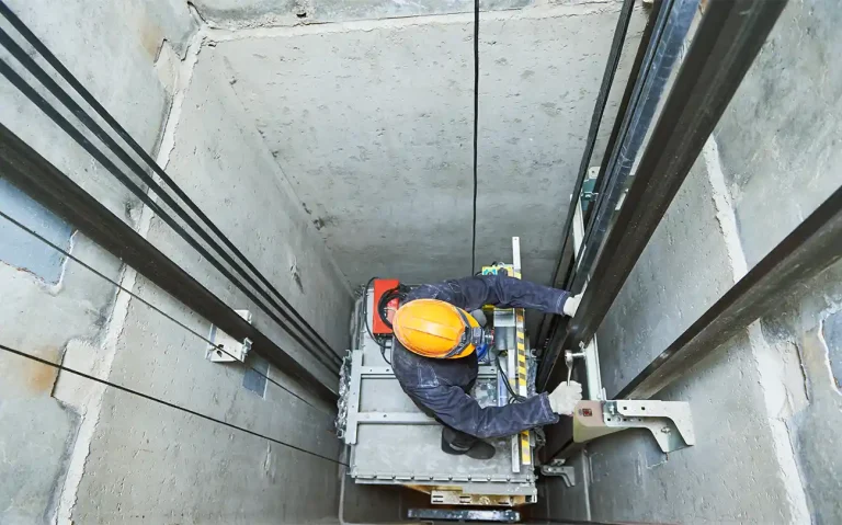 Man installing a signal repeater in an elevator